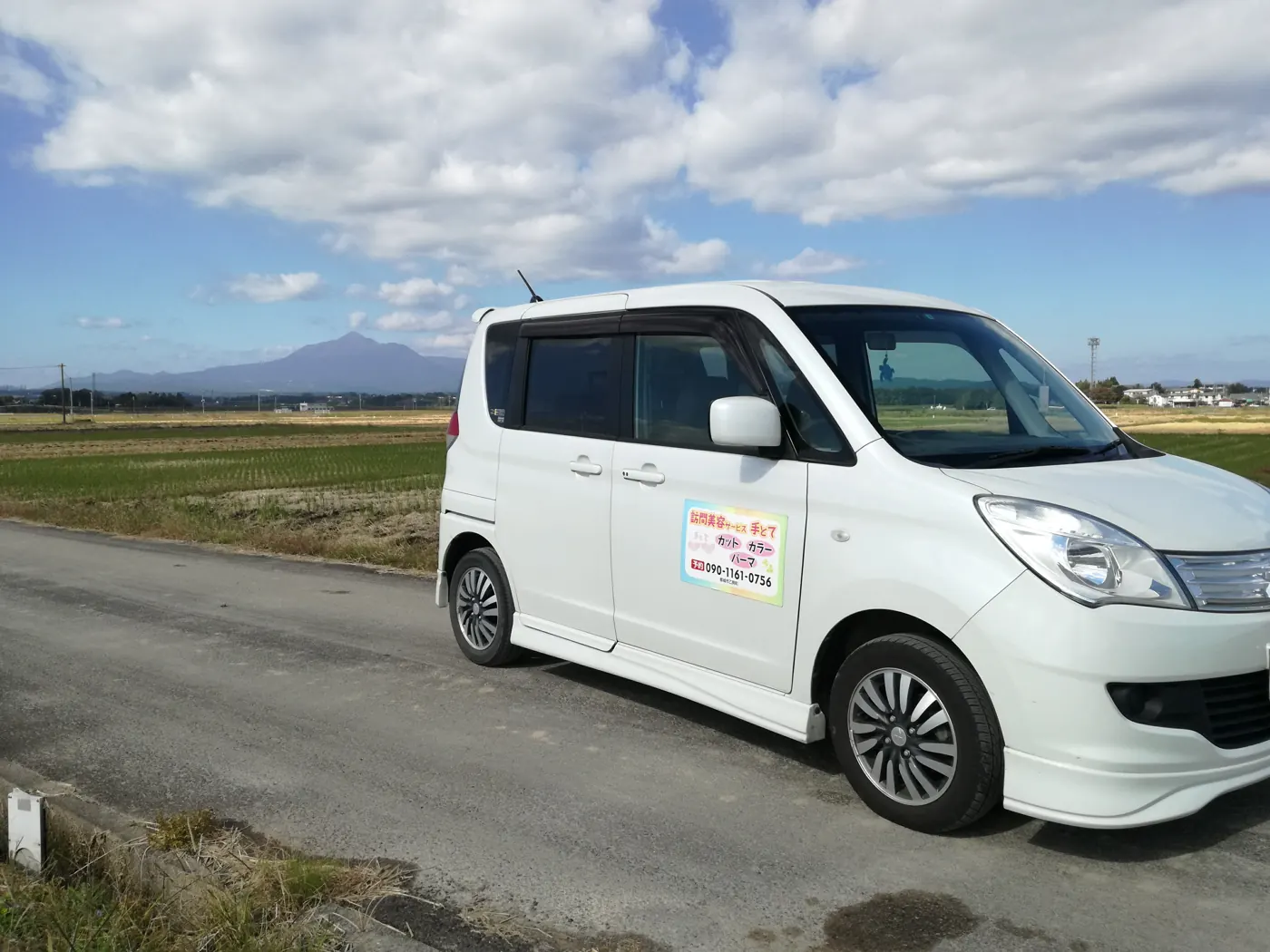 訪問に使っている白い車と都城の田園風景